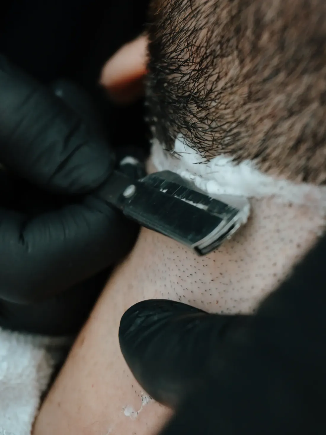 Navalha fazendo o acabamento do contorno da barba no pescoço